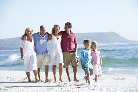 42396388 - three generation family walking along beach